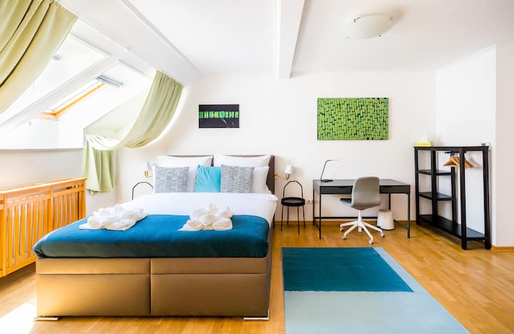 Lichte, ruime slaapkamer met een comfortabel tweepersoonsbed, dakramen en een rustige, luchtige uitstraling.