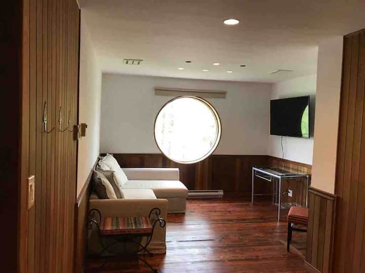 Cama tamaño queen del sexto dormitorio con TV inteligente de pantalla plana.