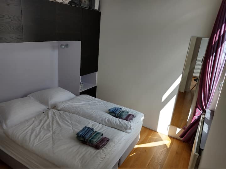 Bedroom with double box spring bed, full-length mirror; directed to backside, so there is no traffic noise