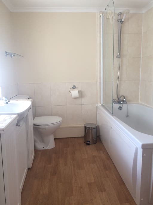 Shared bathroom with bath and shower.