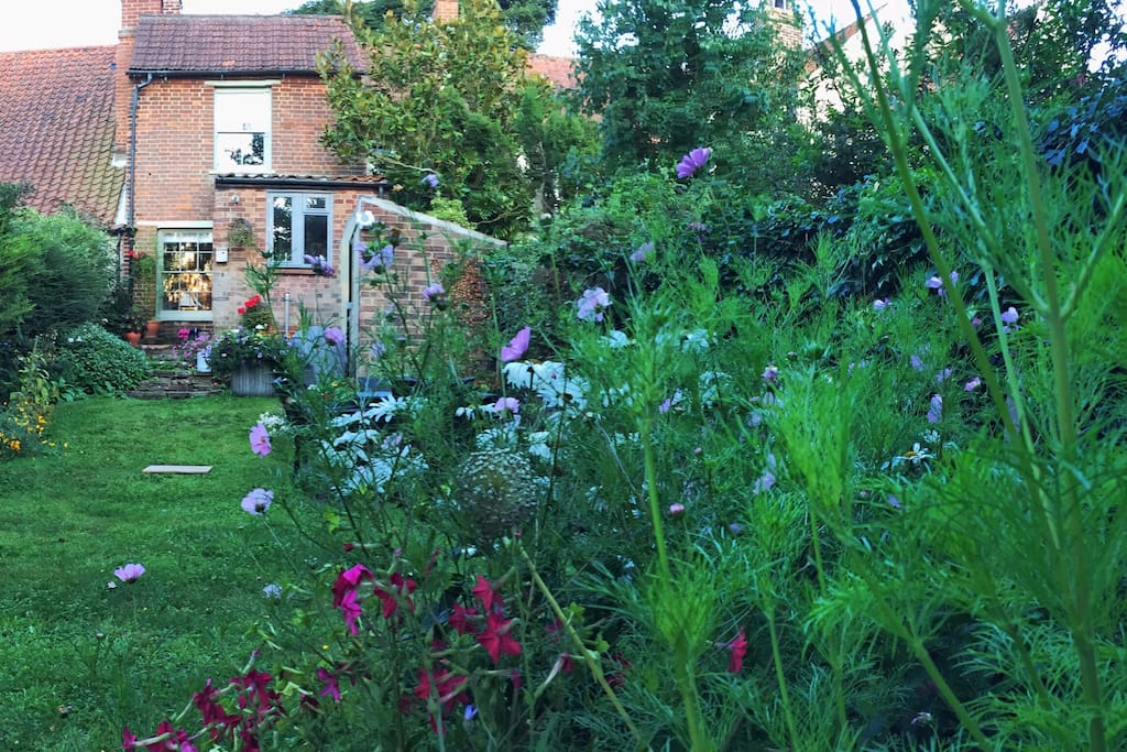 100 ft back grassed garden with well established borders and small herb garden. Table and chairs and BBQ. Plus kids play shed and trampoline in landscaped area overlooking pretty river and fields.