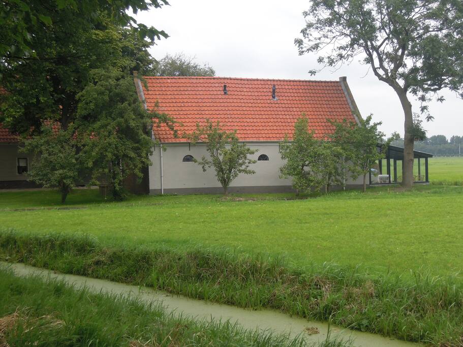 Als u over de dijk aan komt rijden, ziet u de achterkant van het koetshuis
