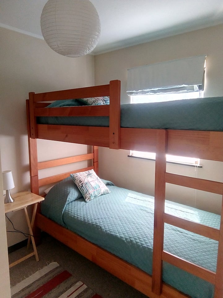 غرفة نوم صغيرة بسرير بطابقين وخزانة
