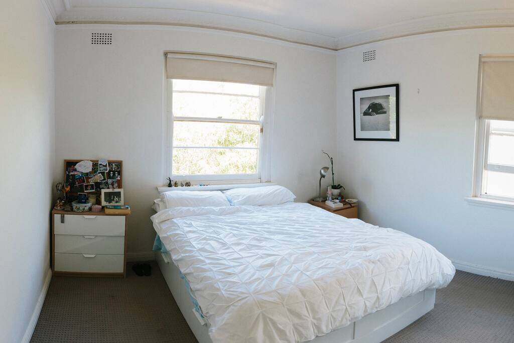 Bright and tidy bedroom with blinds.