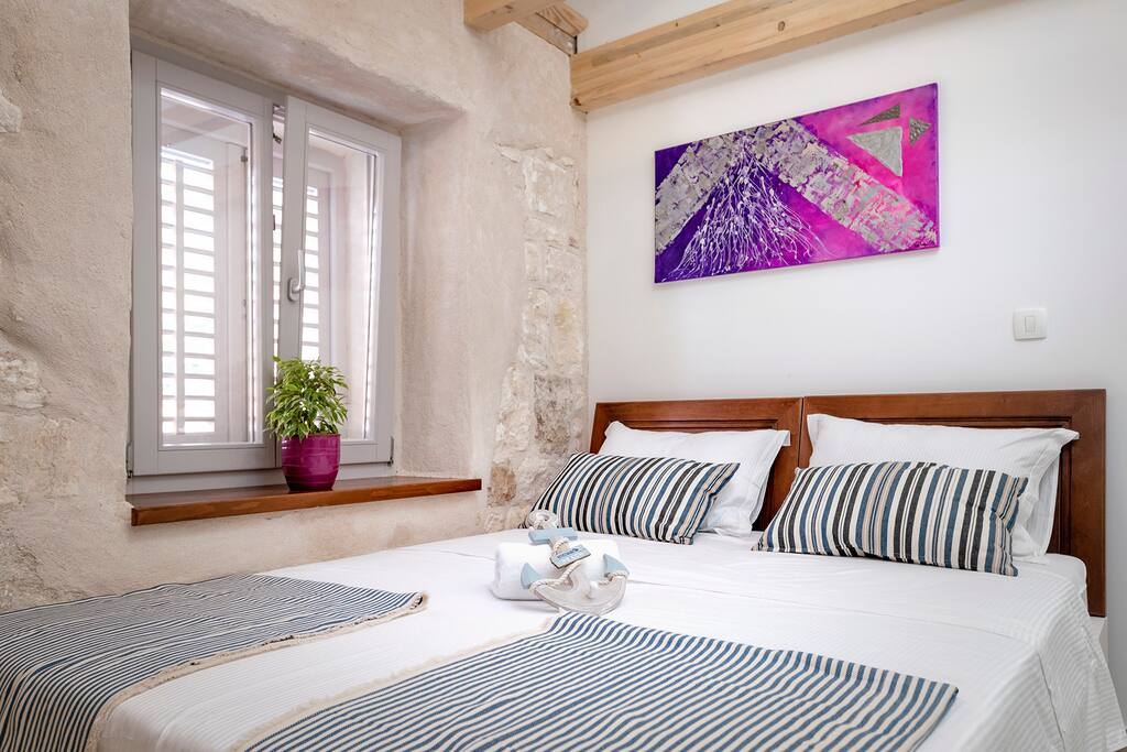 Double bed with the painting made by the local painter. The room has A/C and satellite smart TV