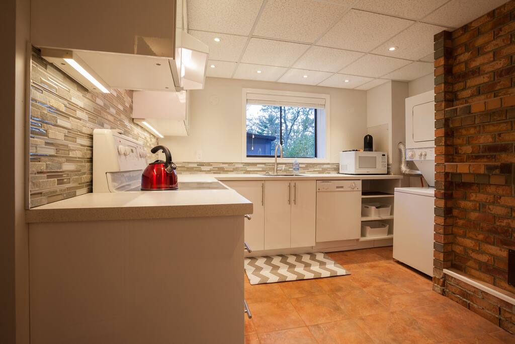 Brand new kitchen with full stove, oven, microwave, dishwasher, and laundry.