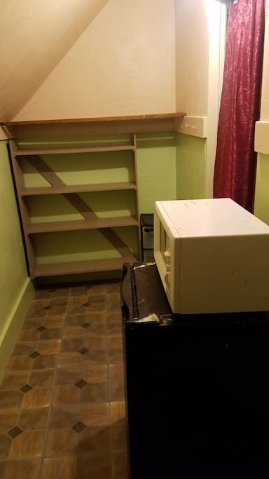 Walk-in closet with mini fridge and microwave.