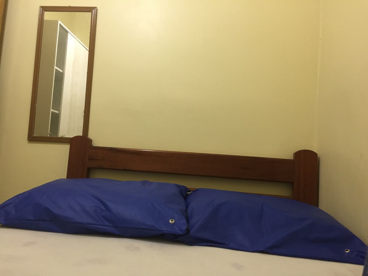 ห้องนอนที่ 4 พร้อมเตียงคู่ตู้เสื้อผ้ากระจกและพัดลมเพดาน
