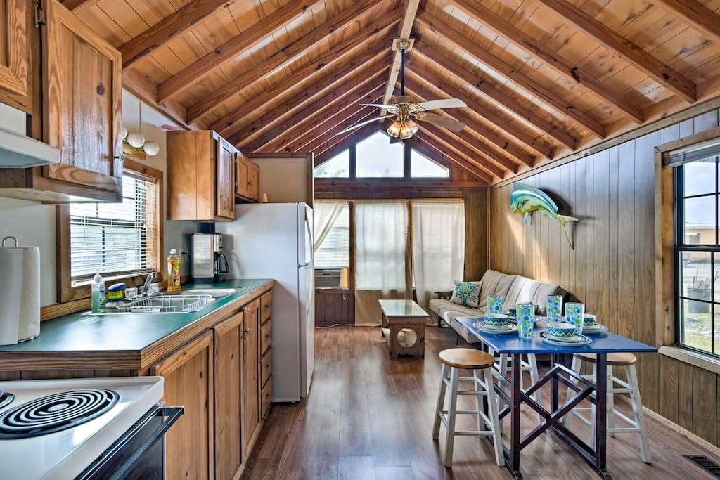 Vaulted ceilings and a wall lined with windows give this quaint cabin an open and spacious feel.