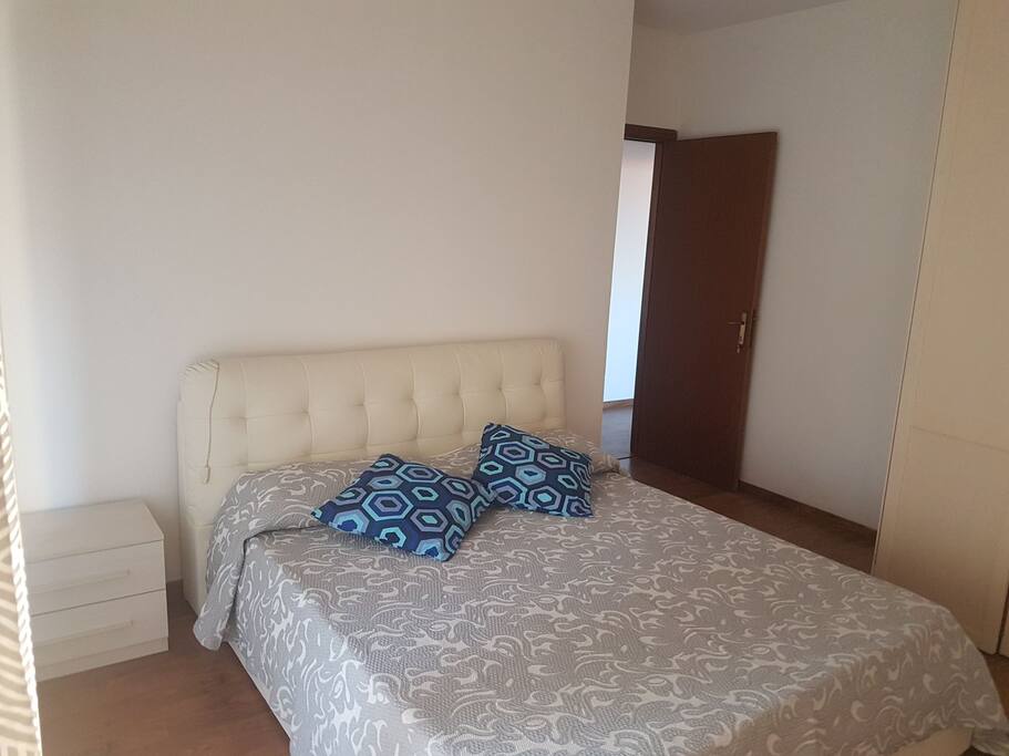 camera matrimoniale con letto e mobili nuovi e pavimento in parquet.