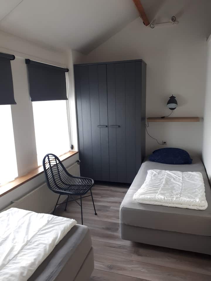 Slaapkamer met 2 eenpersoonsbedden (90x200) en kledingkast
Ramen met verduisterings-rolgordijnen