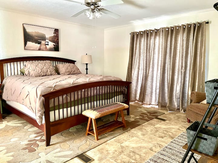 Chumba kikuu cha kulala kimesasishwa na mapazia meusi kwa ajili ya mapumziko ya usiku wenye amani.