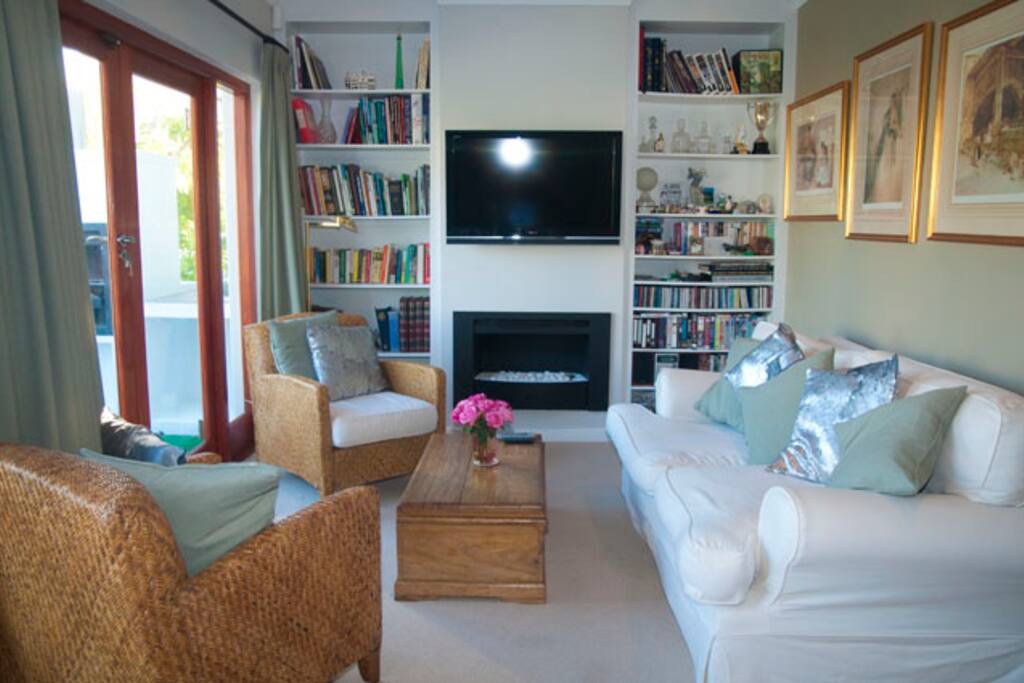 Living room with DSTV, fireplace, access to balcony and mountain views.