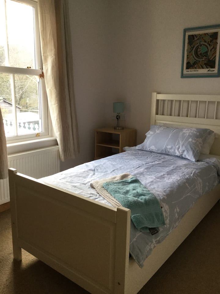 Clean and comfy single bed in bright and airy bedroom.