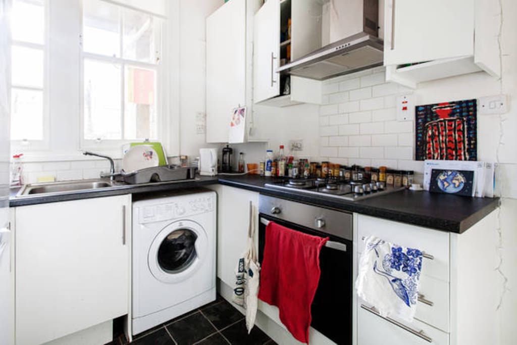 Shared kitchen with gas hob, washing machine and a fridge.