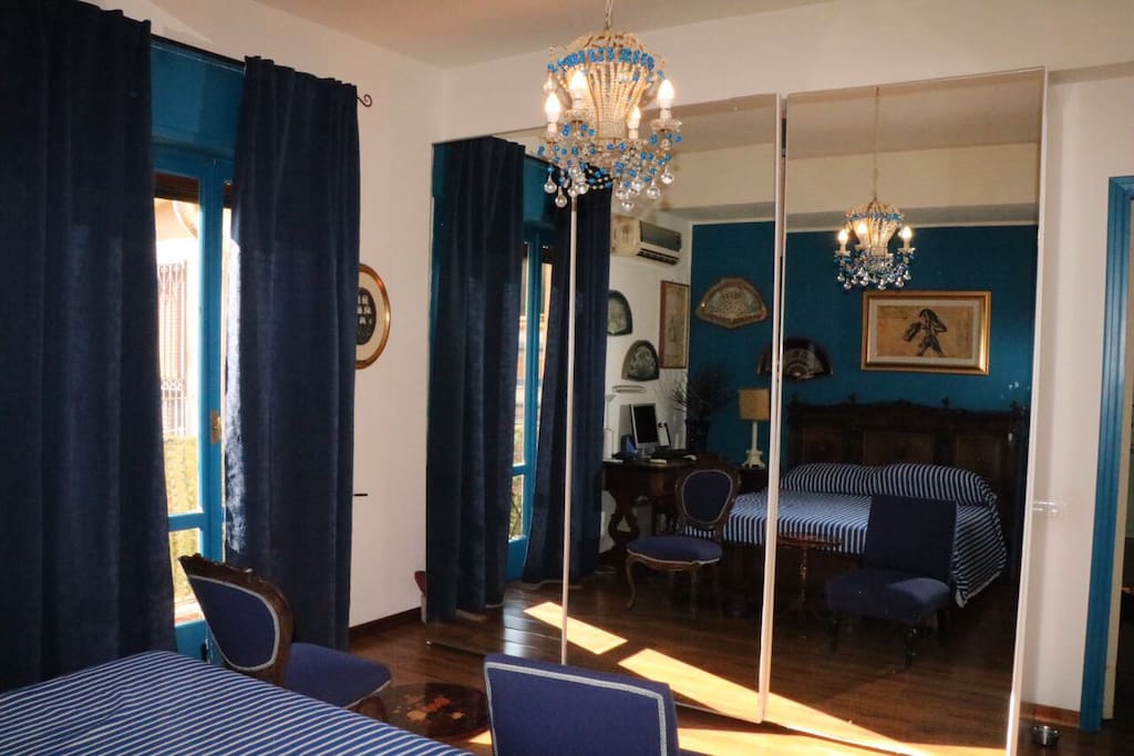 La luce filtra dalla grande vetrata del balcone sui cristalli dell'antico lampadario
