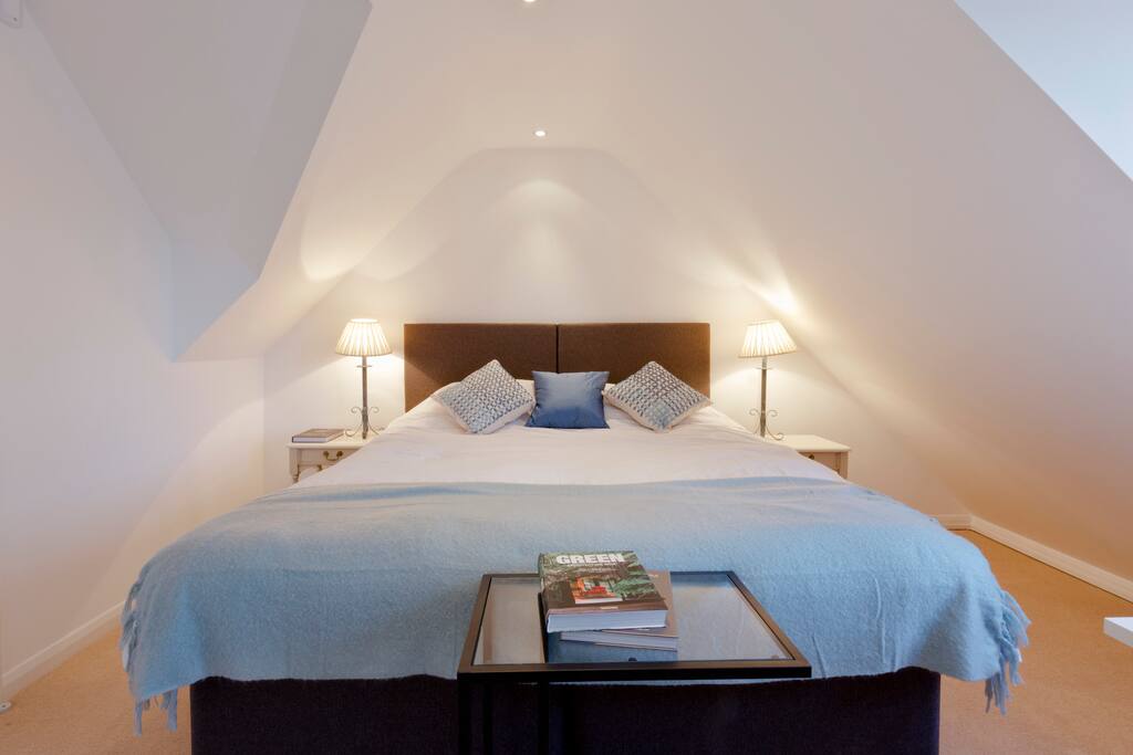 King-sized double bed with lamp + tables on each side