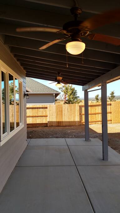 Unfinished backyard with covered patio, it's a nice place to sit even in the sunny summer heat.