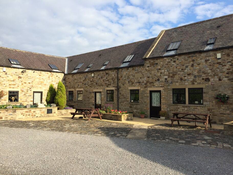 The cottage leading out onto the court yard. Seating area and pond.