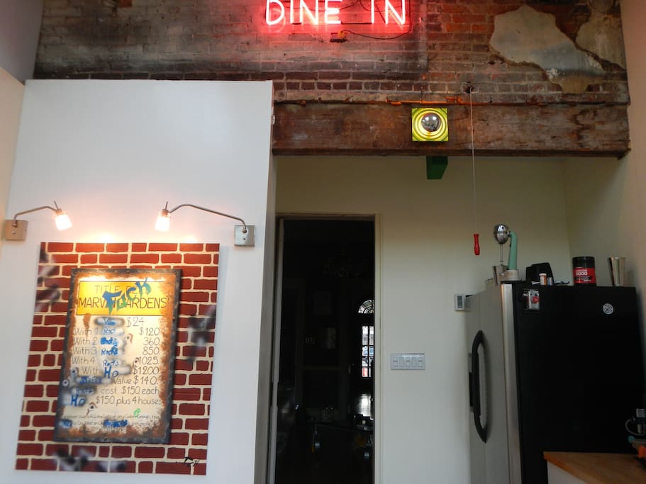 Exposed brick and beam, neon, custom art in kitchen.