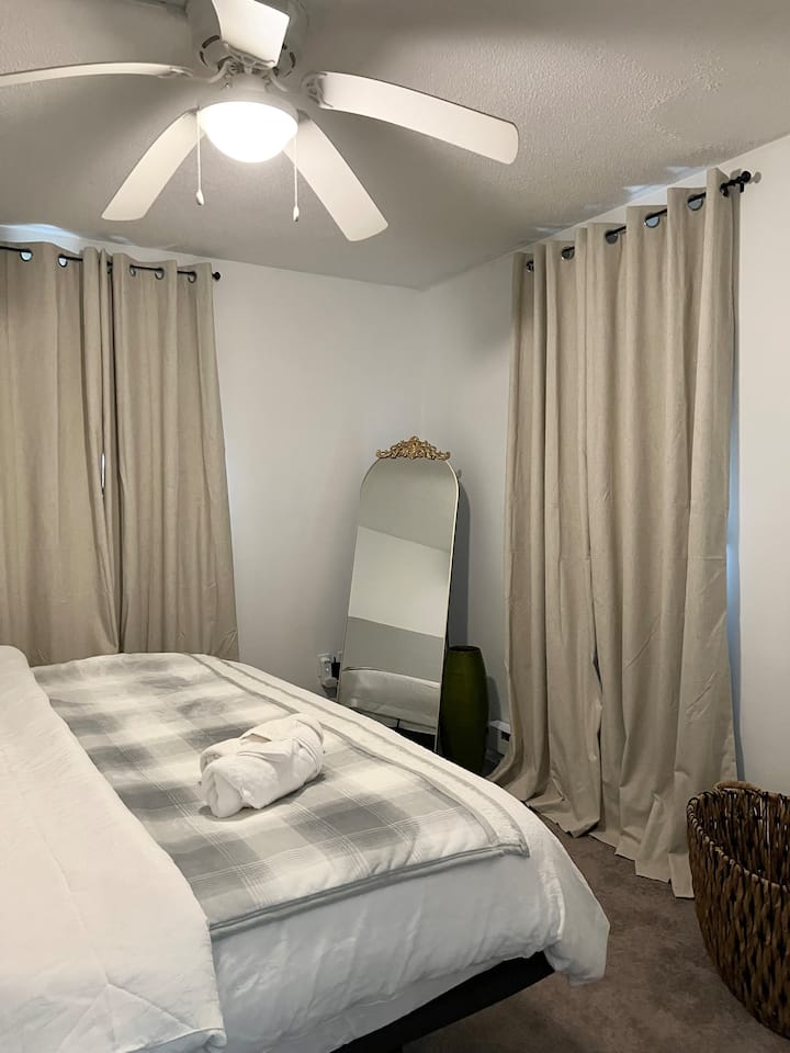 غرفة نوم في الطابق السفلي تتميز بسرير كبير.