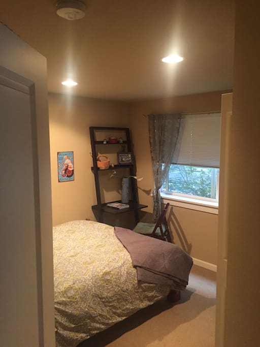 Your private bedroom while you visit. View from the door. Window at treetop level