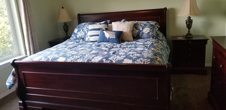 غرفة نوم رئيسية بسرير بحجم كبير وخزانة ملابس وتلفزيون