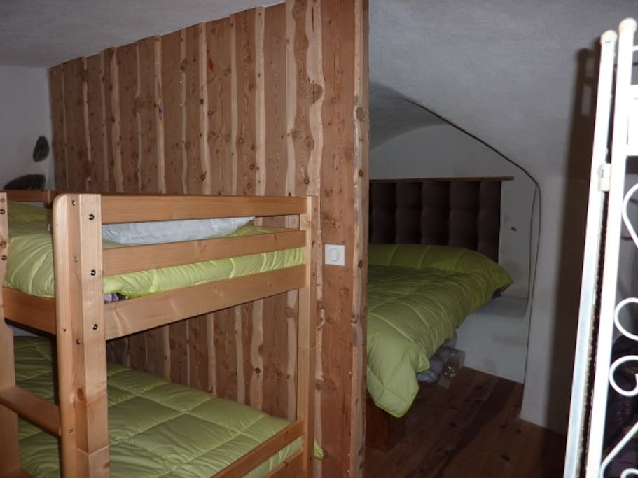 coin nuit : un grand lit 2 personnes et 2 lit superposés.