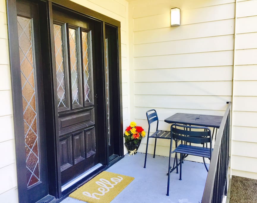 Front door with patio table and seating.