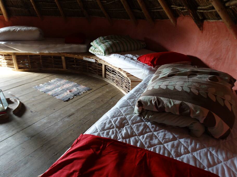 the comfortable single beds with warm duvets and pillows are placed in a ring around the walls on raised wooden benches