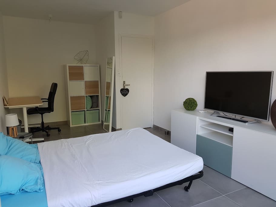 Grande chambre avec TV écran plat, bureau et rangements