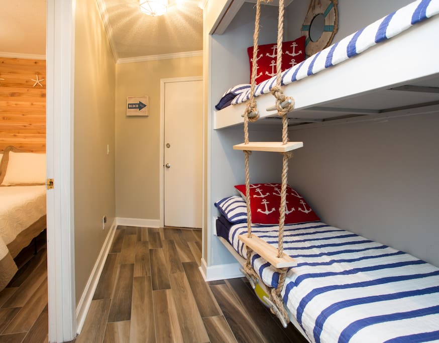 Bunks are located in hallway outside of bedroom door