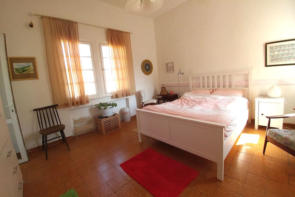 Overview of the room: king size bed, 2 windows, 2 doors, closet, a mirror, exit to a private balcony