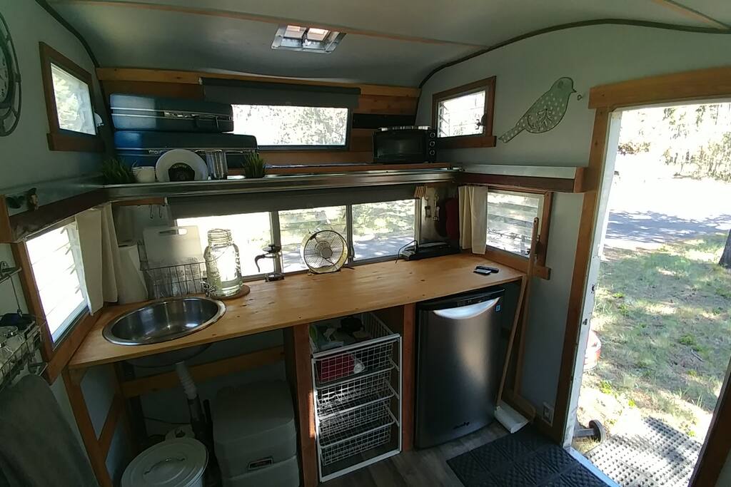 Drain sink, drawers, mini-fridge, toaster oven, hot plate, kettle - plus the basics for camping (paper plates, cups, utensils, paper towels, etc.)
