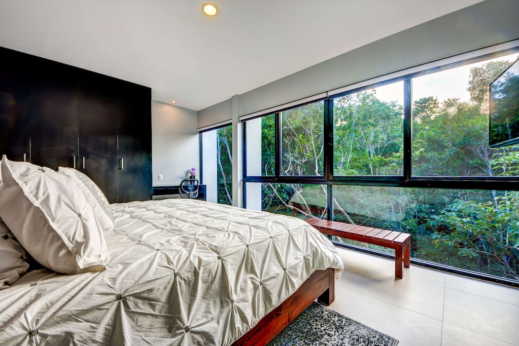 Main bedroom with large windows for an amazing jungle view