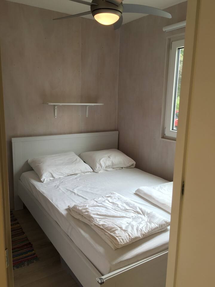 Hlavná spálňa so stropným ventilátorom a oknami vybavenými sieťkami proti komárom.