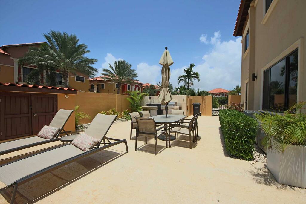 BBQ-grill area with an outdoor dining table and umbrella