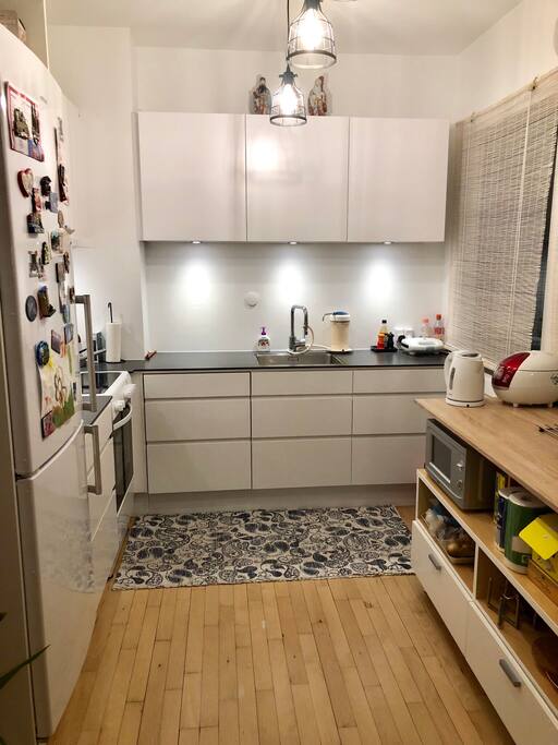 Modern kitchen with refrigerator, stove/oven and microwave oven.