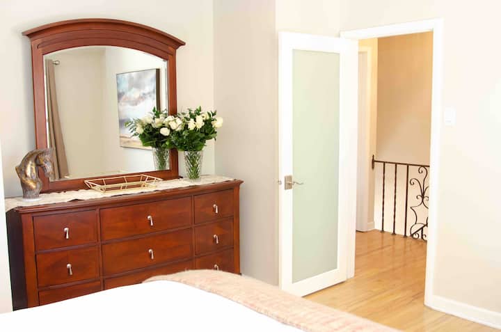 Here is the dresser I mentioned. You could stay for months and fill it up with clothes! Reading lamps on bedside tables flank a Queen bed in this room. Nothing was overlooked here. Blackout curtains for good rest, and two robes are in the closet.