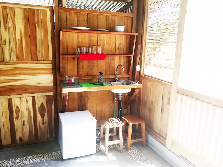 Small kitchen, features refrigerator, sink and basic utensils.