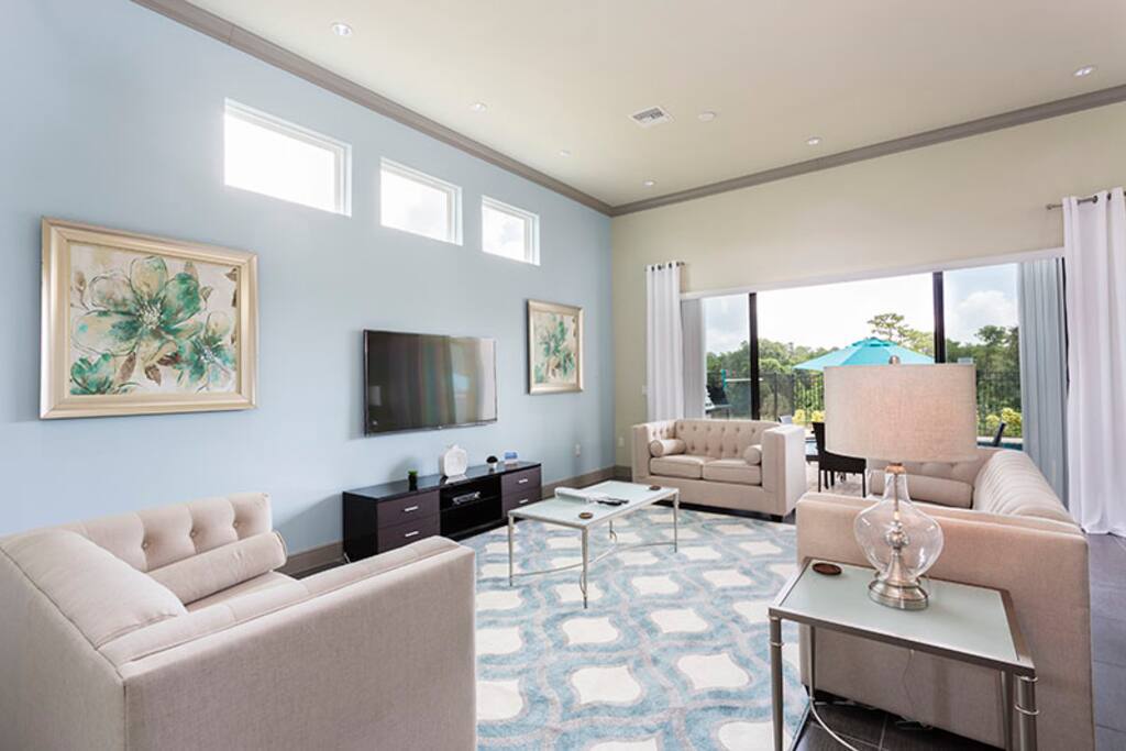 The living room is beautifully decorated with a 60 inch SMART TV and light colors