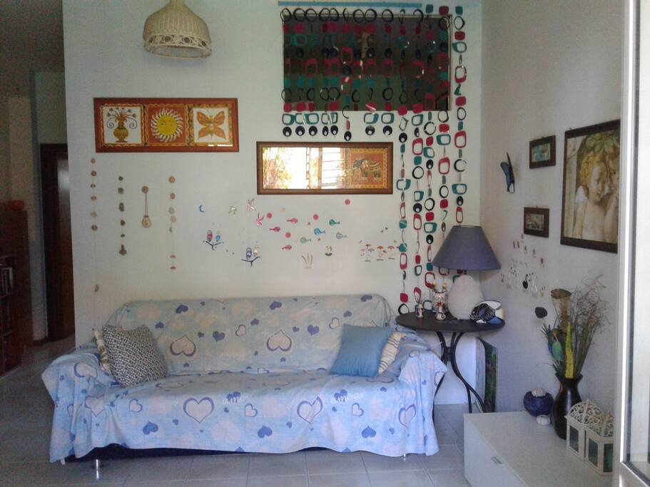 Salone con divano letto matrimoniale ed angolo cottura.
