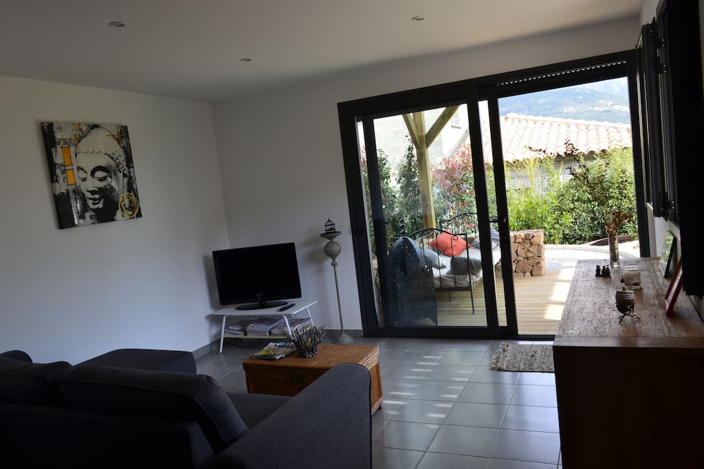 Appartement de plain pied avec ouverture sur terrasse en bois abritée.