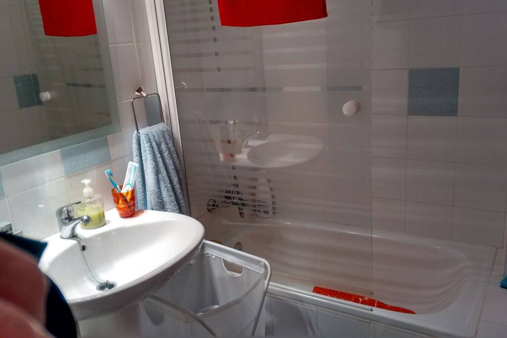 Cuarto de baño con bañera y mampara de cristal. Disponibilidad de calefactor a petición del huesped