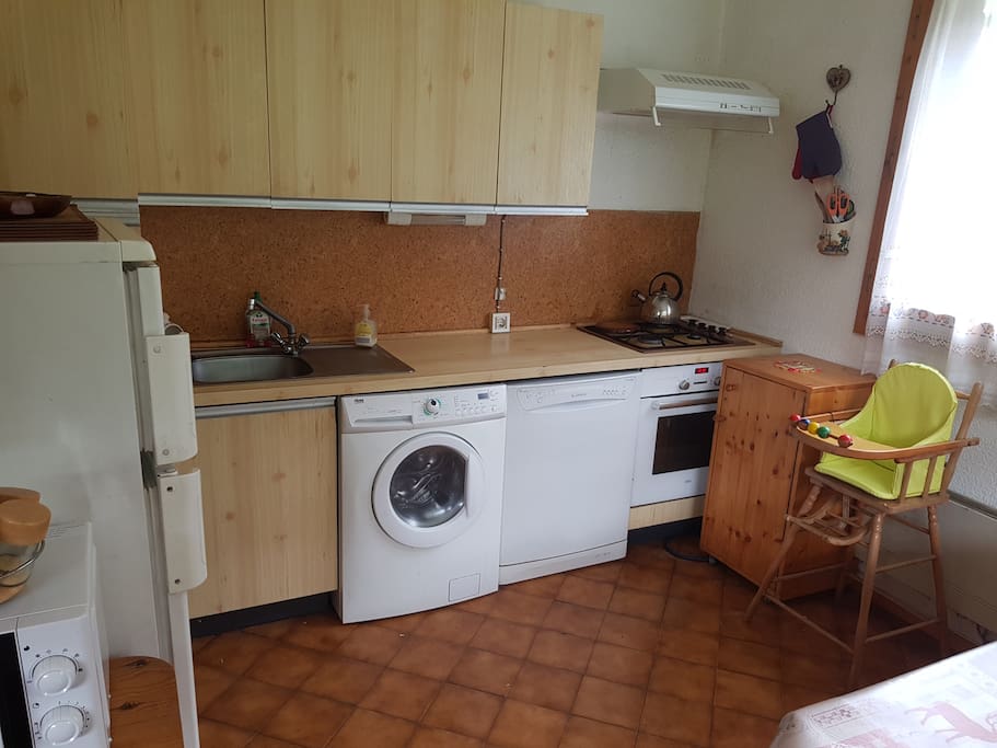 Cuisine avec machine à laver, frigo, petit congélo, four, bouilloire, lave vaisselle etc