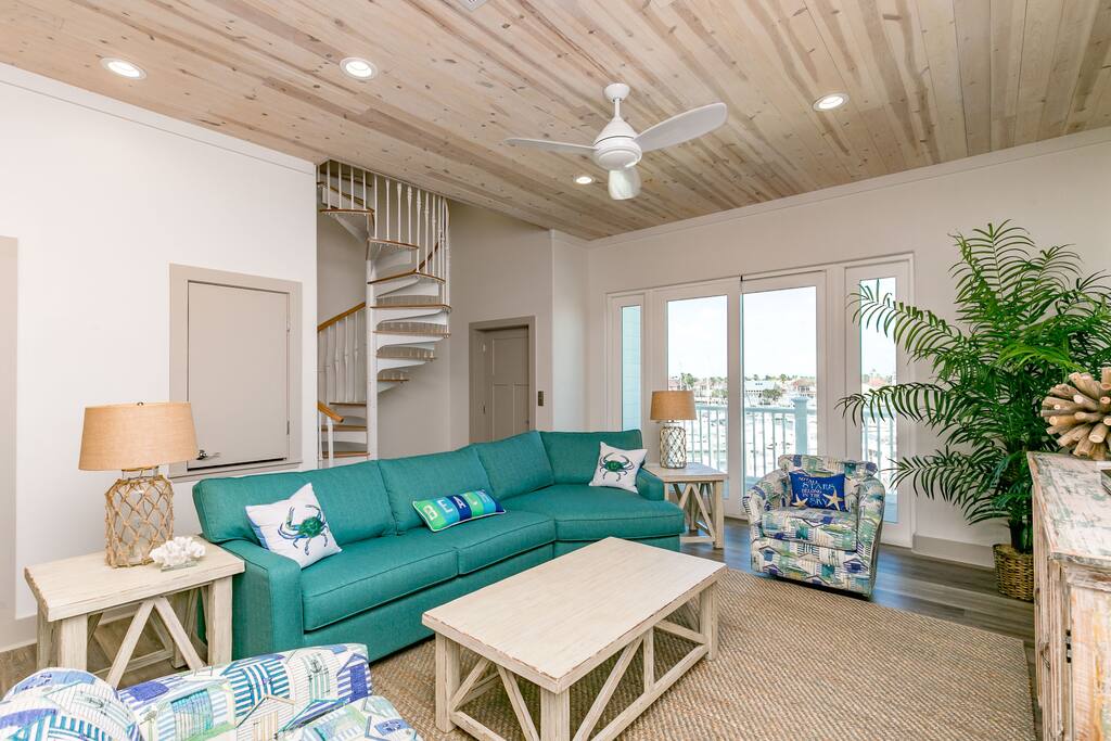 A light-filled living room with couch and armchairs