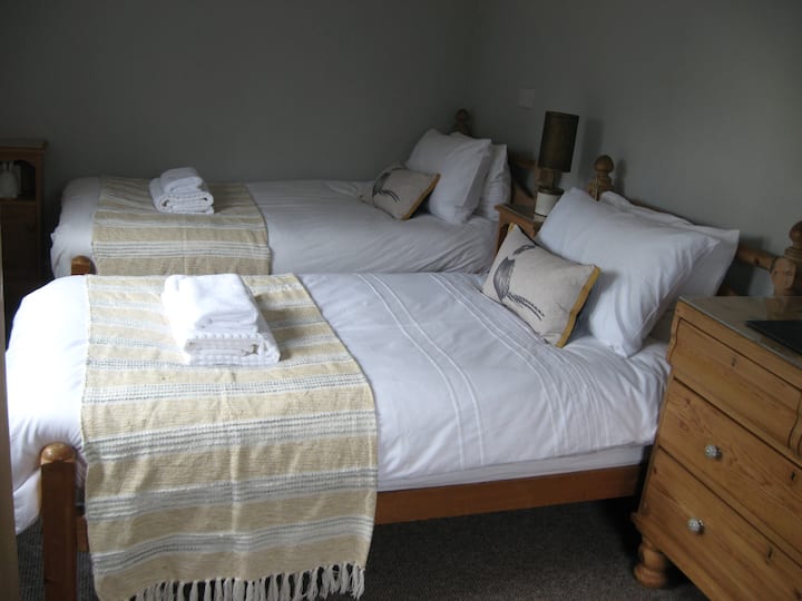 Dvojlôžková izba s rozkladacími pohovkami v plnej veľkosti z bývalého waleského statku. Izba s výhľadom na disk a súkromný pruh.