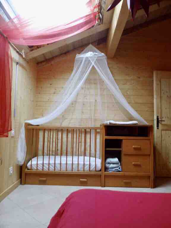 ห้องนอนสีแดงพร้อมเปลไม้เนื้อแข็ง