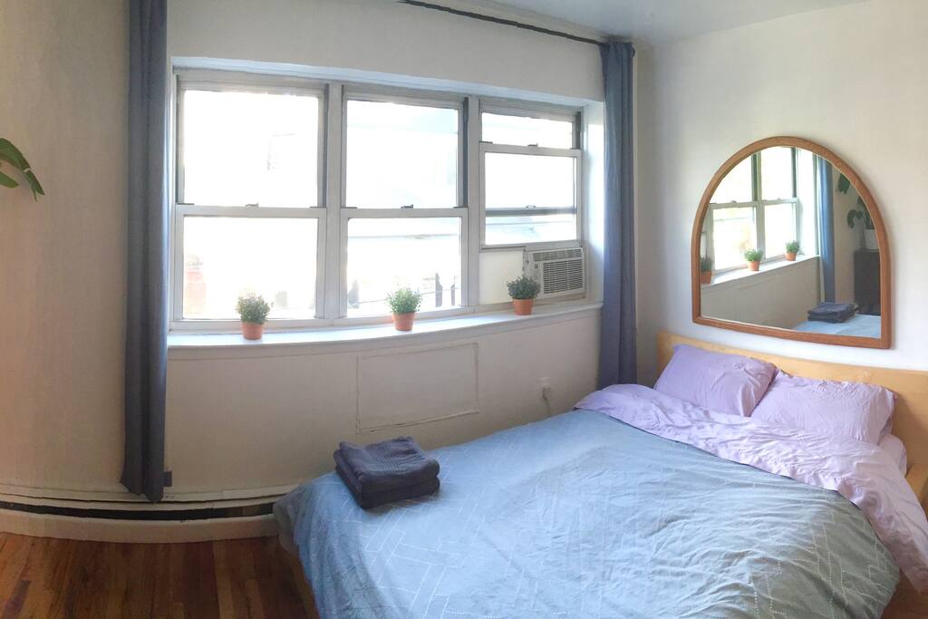 Bedroom #1 has an ultra comfortable queen bed and is clean and bright with a dresser, closet, and plants.