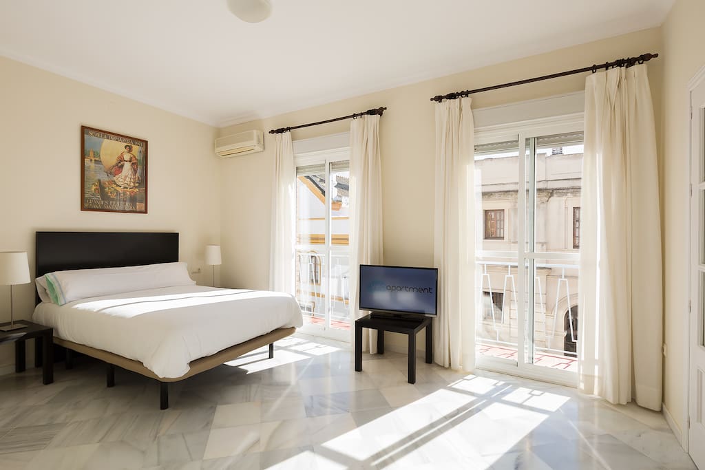 Master bedroom with a double bed. Two windows face the pedestrian Rioja street.